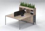 Face-to-face oak workstation with slate grey drawers and black acoustic screen.
